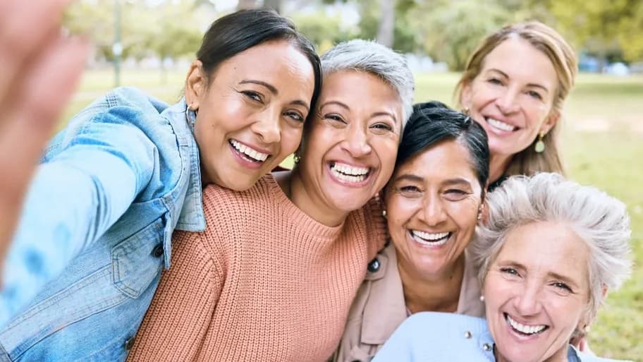 Group of smiling women feeling supported through menopause care.